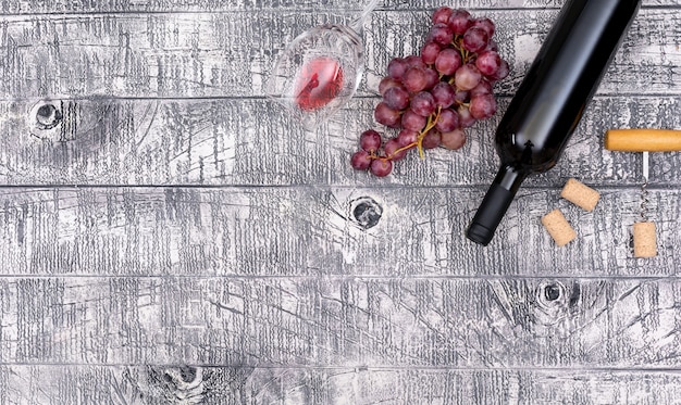 Vista superior botella de vino con uva y copia espacio en madera blanca horizontal