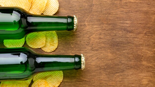 Vista superior de botellas de cerveza y patatas fritas con espacio de copia