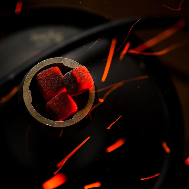 Foto gratuita vista superior brasas humeantes con gotas de fuego en matraz de acero