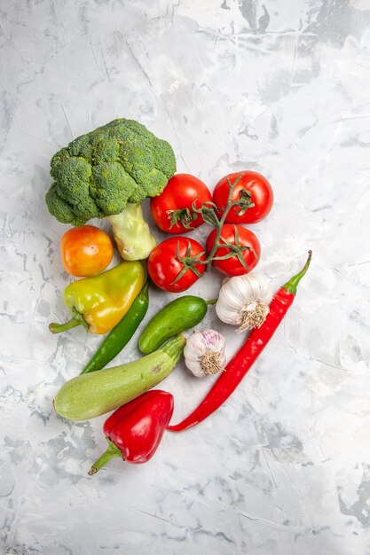 Vista superior de brócoli fresco con verduras en ensalada de mesa blanca salud madura