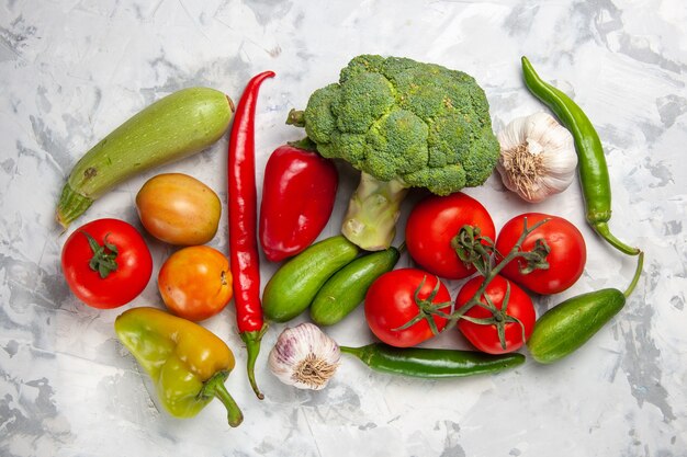 Vista superior de brócoli verde fresco con verduras en ensalada de mesa blanca dieta de salud madura