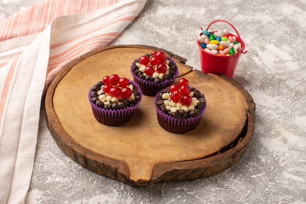 Vista superior de brownies de chocolate con arándanos y caramelos por todo el escritorio de luz pastel galleta masa para hornear dulce