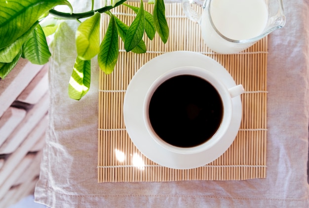 Foto gratuita vista superior de café y leche en estera de bambú