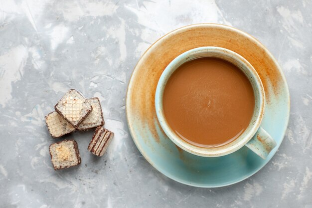 Vista superior de café con leche con gofres de chocolate en el azúcar dulce de galleta de chocolate de fondo claro
