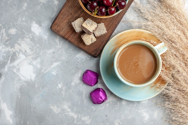 Vista superior de café con leche con gofres guindas frescas en el fondo claro galleta dulce azúcar hornear fruta