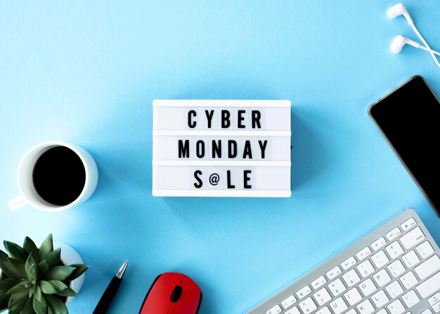 Vista superior de la caja de luz cyber monday con teléfono inteligente y café