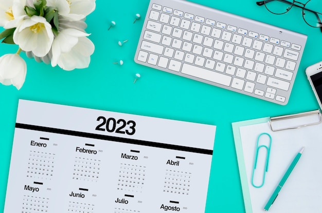 Foto gratuita vista superior del calendario 2023 con teclado y flores.