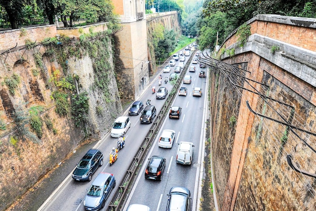 Vista superior de una calle concurrida en la antigua ciudad de roma italia la calle está llena de autos y scooters muchos vehículos atrapados en atascos de tráfico gran problema de tráfico y contaminación del aire en las ciudades antiguas