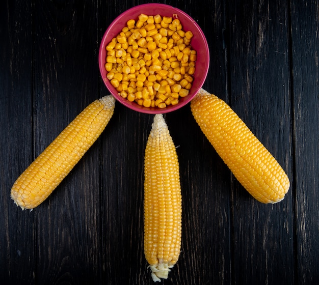 Foto gratuita vista superior de callos cocidos con tazón de semillas de maíz cocido en superficie negra