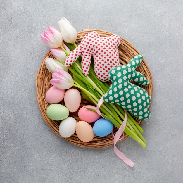 Vista superior de la canasta con huevos de pascua y tulipanes