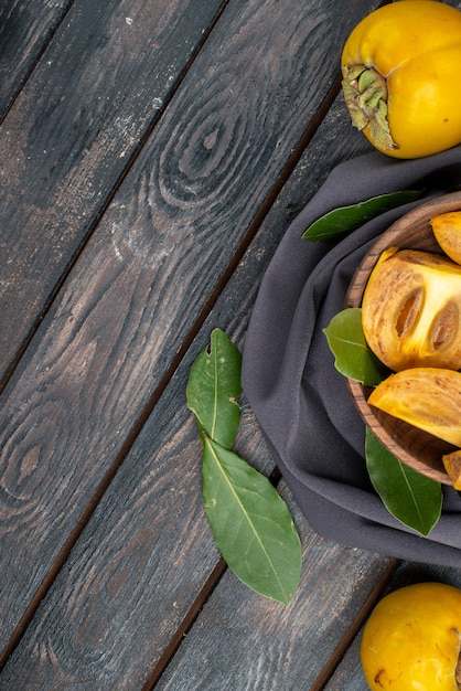 Vista superior caquis dulces frescos en una mesa de madera, fruta madura suave