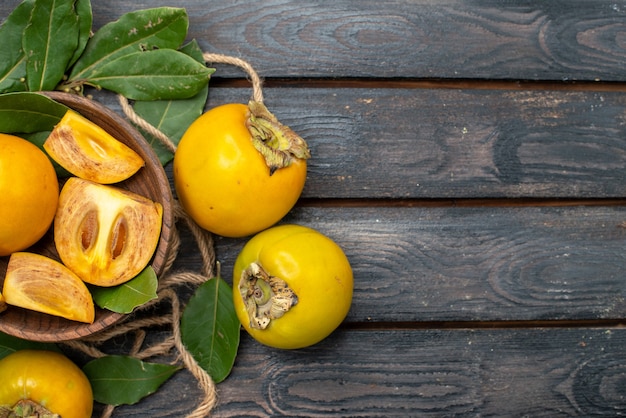 Vista superior de los caquis dulces frescos en la mesa rústica de madera, pruebe la fruta madura