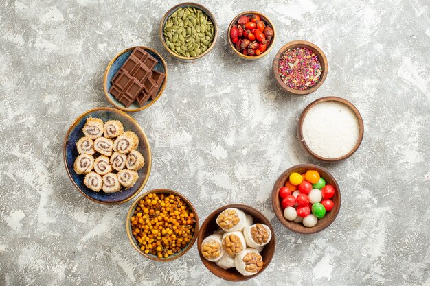 Vista superior de caramelos de colores con caramelos de rollo dulce en mesa blanca color caramelo dulce