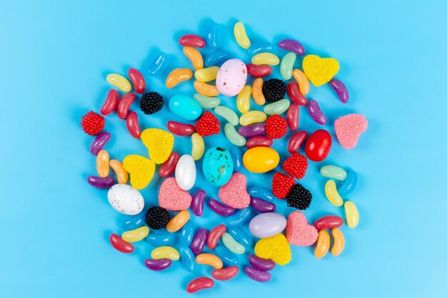 Una vista superior caramelos de colores composición dulce y sabrosa en azul