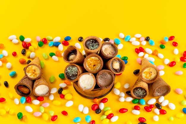 Una vista superior de caramelos de colores junto con helado de cuerno en amarillo