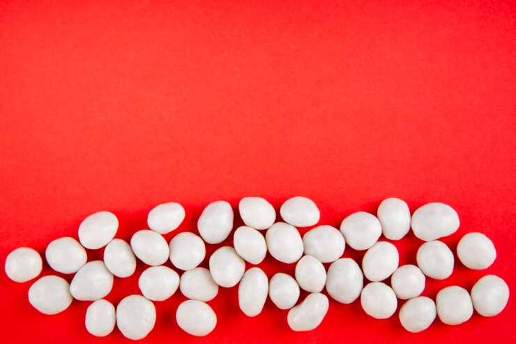 Foto gratuito vista superior de caramelos en esmalte en la parte inferior sobre fondo rojo con espacio de copia