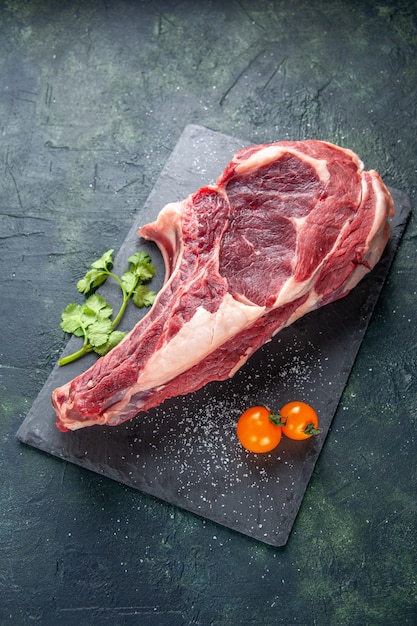 Vista superior de la carne cruda grande rebanada de carne en la superficie oscura