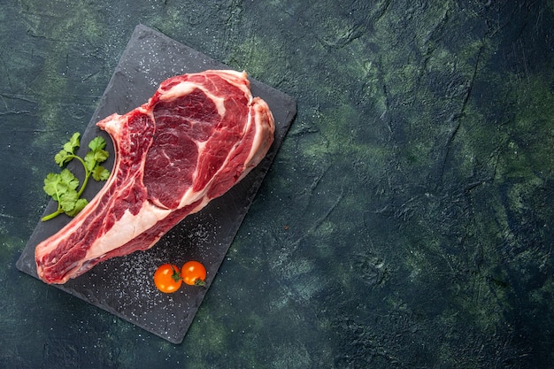 Foto gratuita vista superior de la carne cruda grande rebanada de carne en la superficie oscura