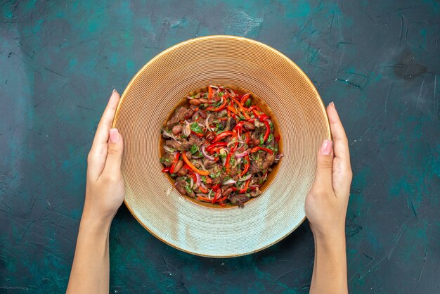 Vista superior de la carne en rodajas con verduras dentro de un plato redondo en la mesa azul oscuro ensalada de comida vegetal