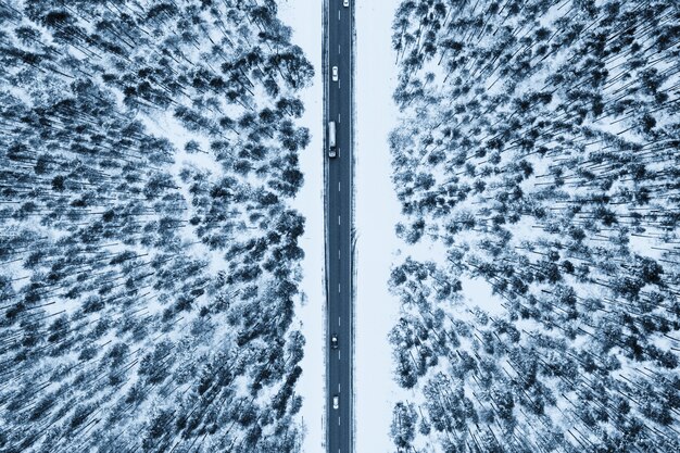 Vista superior de una carretera rodeada de nieve y abetos