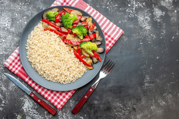 Vista superior de cebada perlada con sabrosas verduras cocidas en mesa gris