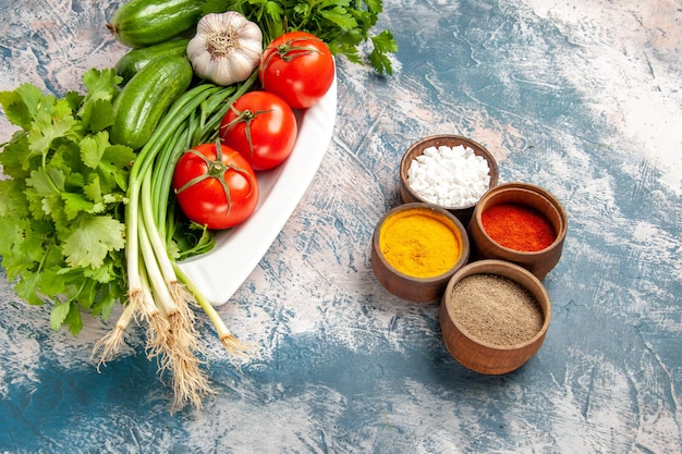 Vista superior de cebolla verde fresca con condimentos y verduras sobre fondo azul claro