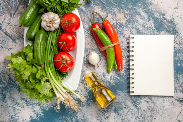 Vista superior de cebolla verde fresca con tomates y verduras sobre fondo azul claro