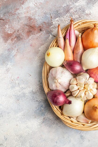 Vista superior de cebollas y ajos ingredientes frescos dentro de la cesta