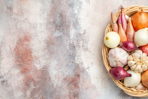 Vista superior de cebollas y ajos ingredientes frescos dentro de la cesta