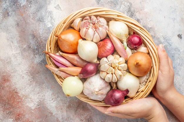 Vista superior de cebollas y ajos ingredientes frescos dentro de la cesta