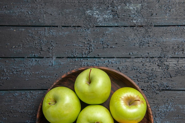 Foto gratuita vista superior de cerca apetitosas manzanas siete manzanas de color amarillo verdoso en placa sobre la superficie oscura