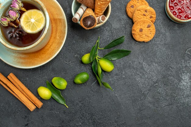 Vista superior de cerca dulces galletas mermelada waffles una taza de té con cítricos de limón