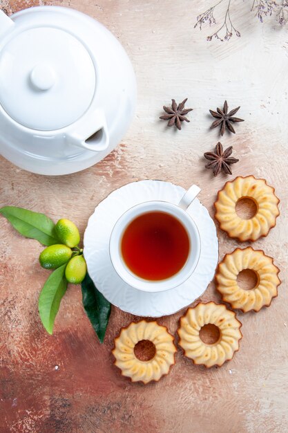 Vista superior de cerca dulces galletas una taza de té anís estrellado tetera