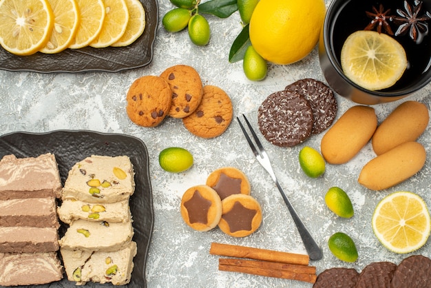 Vista superior de cerca dulces una taza de té tenedor galletas semillas de girasol halva cítricos