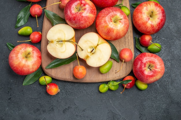 Vista superior de cerca frutas cítricos junto a las manzanas y cerezas en el tablero