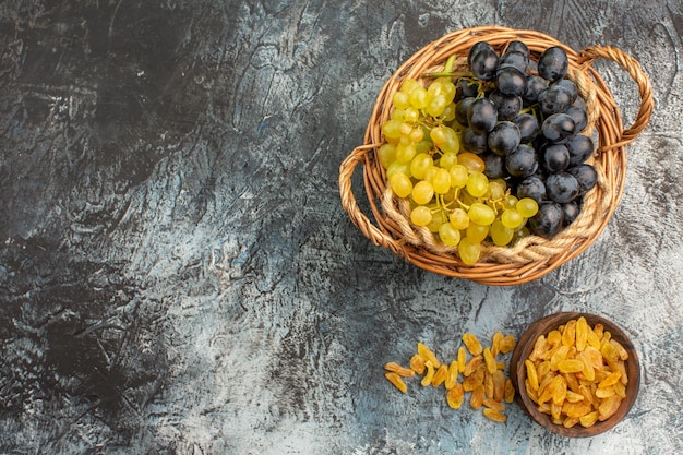 Foto gratuita vista superior de cerca frutas frutos secos en el cuenco las apetitosas uvas verdes y negras