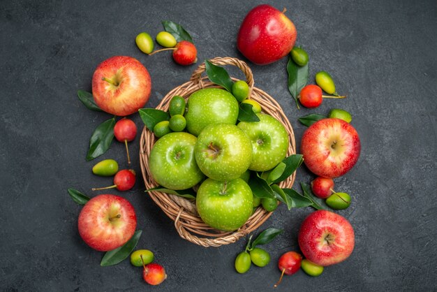 Vista superior de cerca frutas manzanas verdes en la canasta junto a las frutas