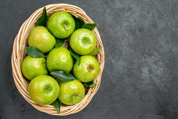 Vista superior de cerca manzanas en la canasta ocho apetitosas manzanas con hojas verdes en la canasta