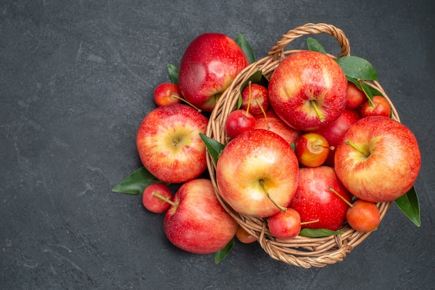 Vista superior de cerca manzanas manzanas de cuerda las apetitosas cerezas en la canasta