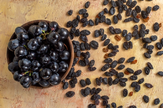 Vista superior de cerca las uvas uvas negras en el cuenco y pasas