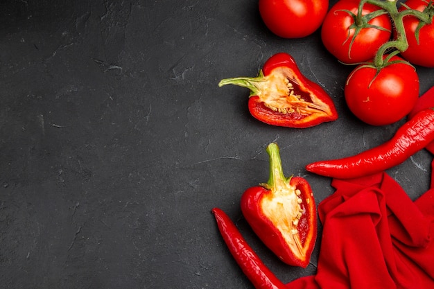 Vista superior de cerca verduras pimientos picantes pimientos tomates con pedicelos sobre el mantel