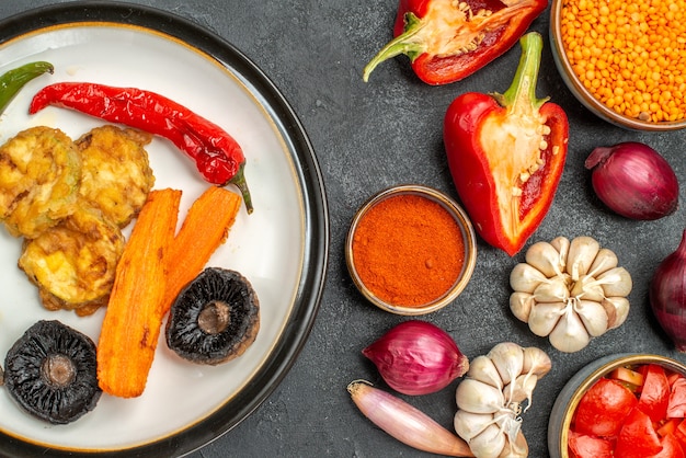 Vista superior de cerca verduras un plato de pimiento y champiñones pimientos tomates especias