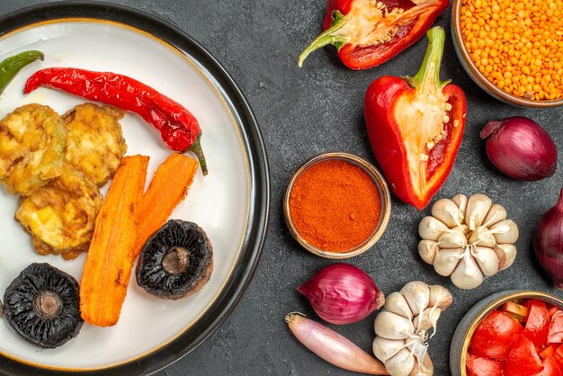 Vista superior de cerca verduras un plato de pimiento y champiñones pimientos tomates especias