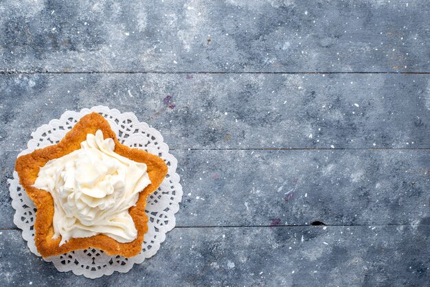 Vista superior cercana de un delicioso pastel horneado en forma de estrella con una deliciosa crema blanca dentro de un escritorio de luz, pastel de azúcar dulce té crema