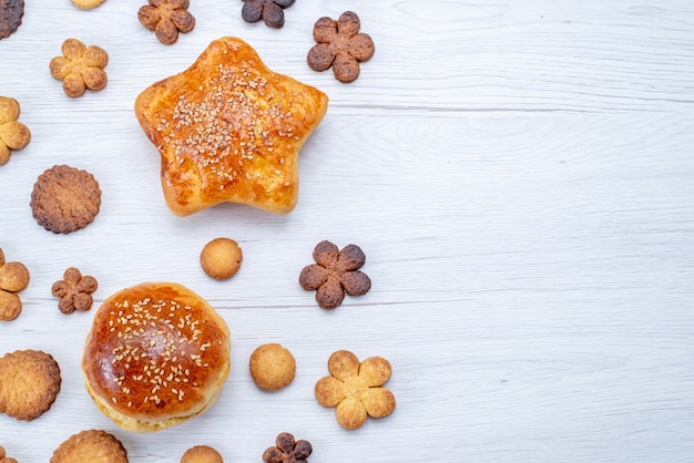 Vista superior cercana de deliciosos pasteles dulces con galletas en el escritorio de luz, pastelería galleta galleta azúcar dulce