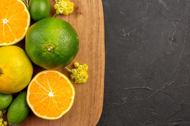 Vista superior cercana mandarinas frescas con feijoa en el espacio oscuro