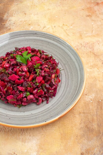 Vista superior cercana del plato de una ensalada roja en el lado izquierdo con verduras sobre un fondo de madera