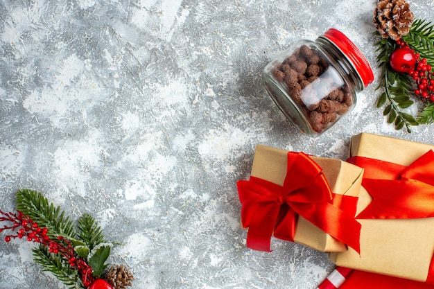 Vista superior de cereales de regalos de Navidad en tarro de ramas de árboles de Navidad en el espacio de copia de mesa gris