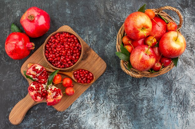 Vista superior de la cesta de frutas de frutas el tablero con cerezas de cuchara de granada