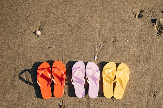 Vista superior de chanclas en la playa con copyspace